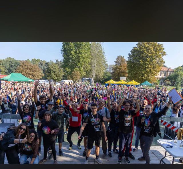 I partecipanti riuniti davanti al palco, in un parco.